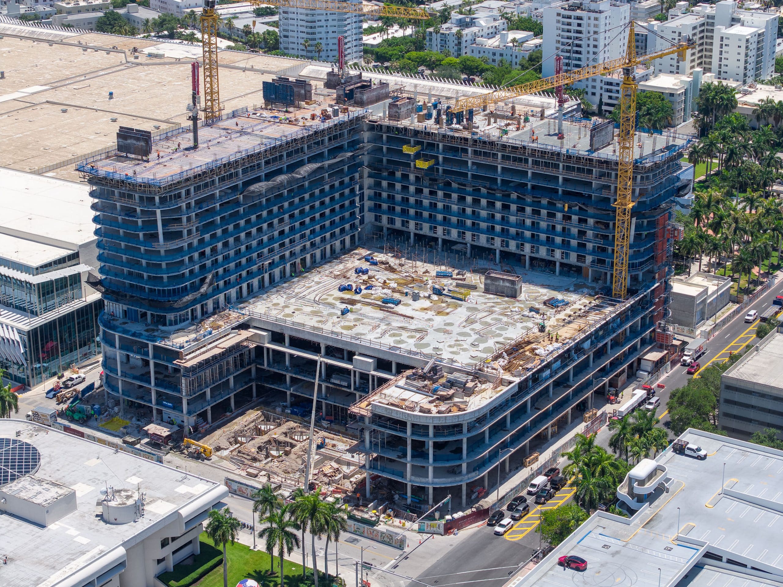 Aerial view of the Grand Hyatt Miami Beach hotel under construction next to the Miami Beach Convention Center, with tower cranes and pool deck taking shape, June 2026