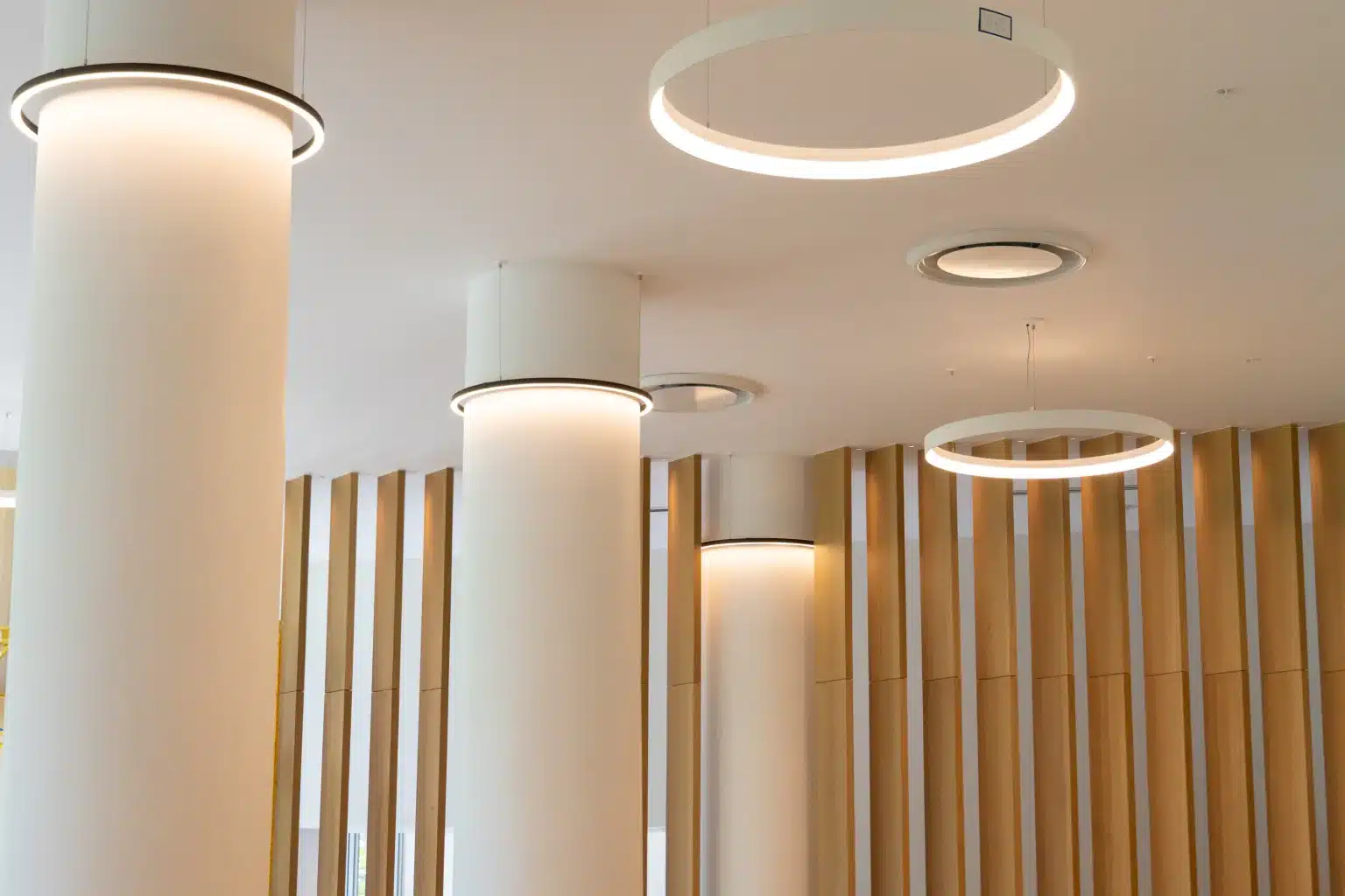 Lobby at Flamingo Point in Miami Beach with round columns, circular cove lighting and vertical wood slat paneling
