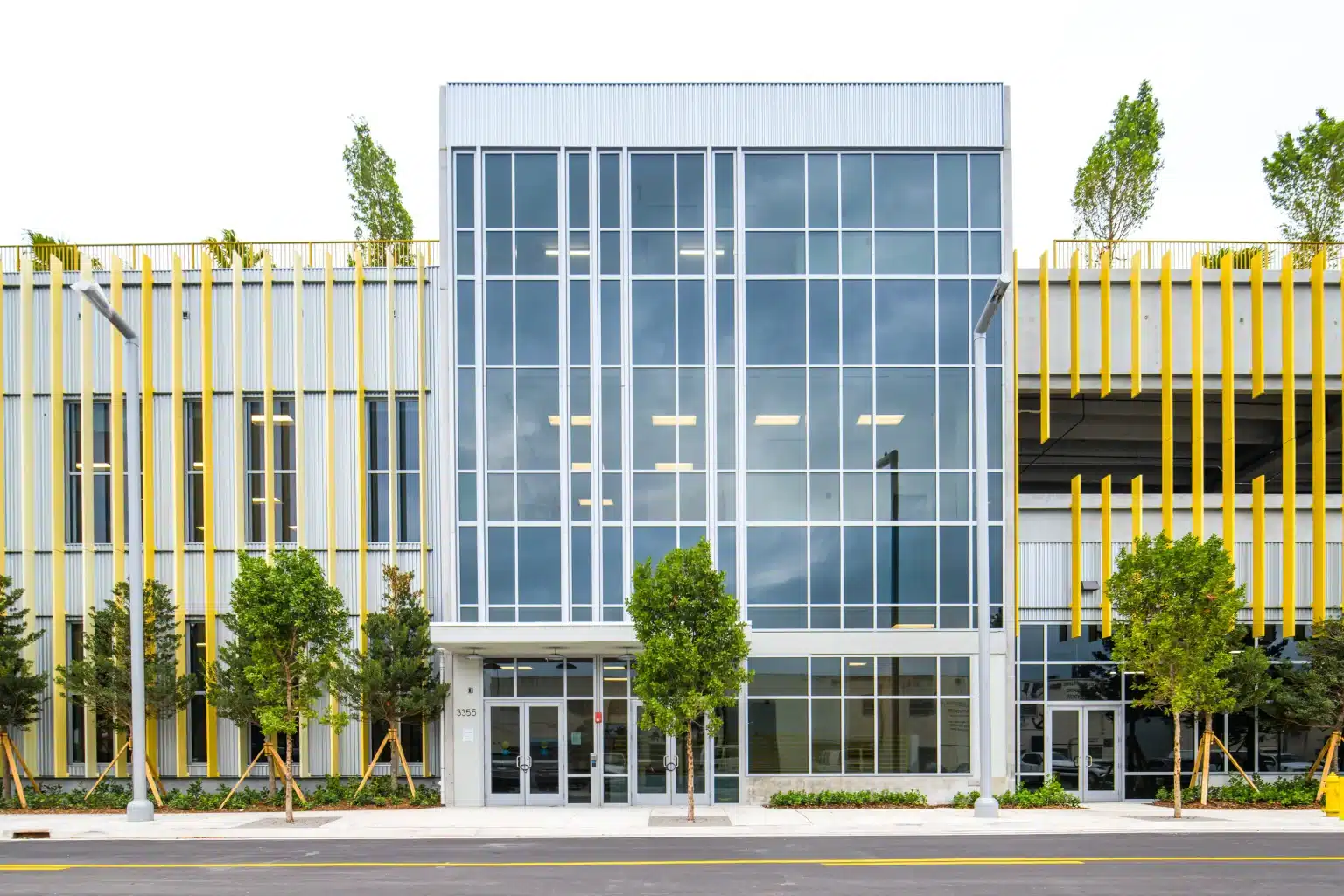 Glass-walled office entrance set between gold vertical fins on the facade of the Palmer warehouse