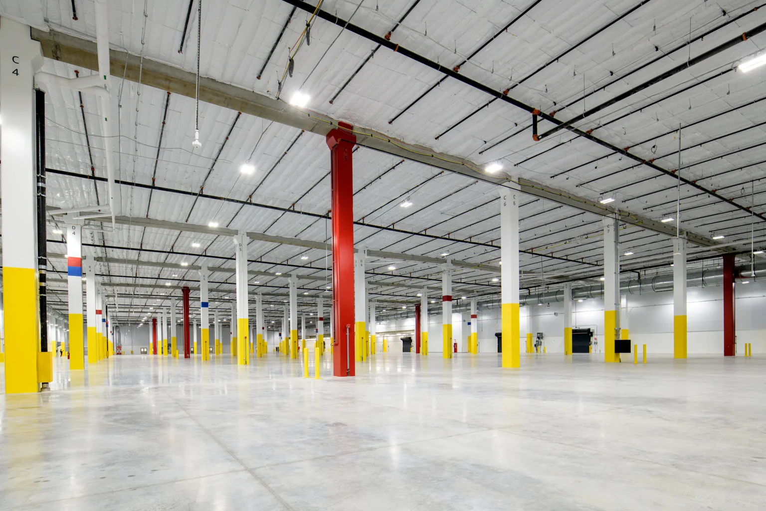 Wide interior of the empty Palmer warehouse with polished concrete floor, steel columns and high-bay lighting