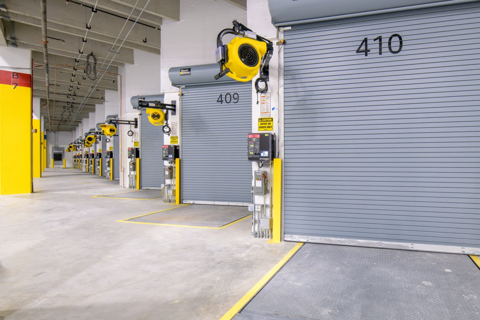 Row of numbered roll-up loading dock doors with installed dock equipment inside the Palmer warehouse